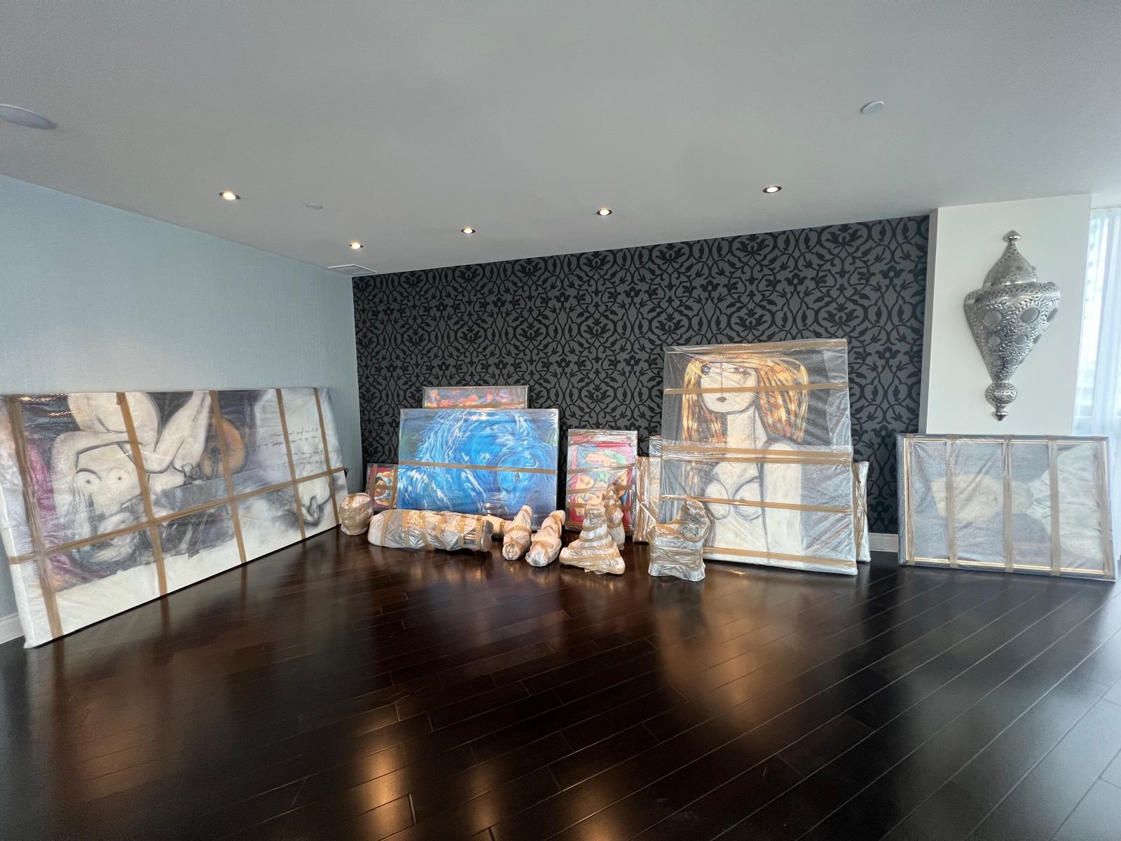 Tableaux encadrés emballés et alignés contre un mur avant le chargement