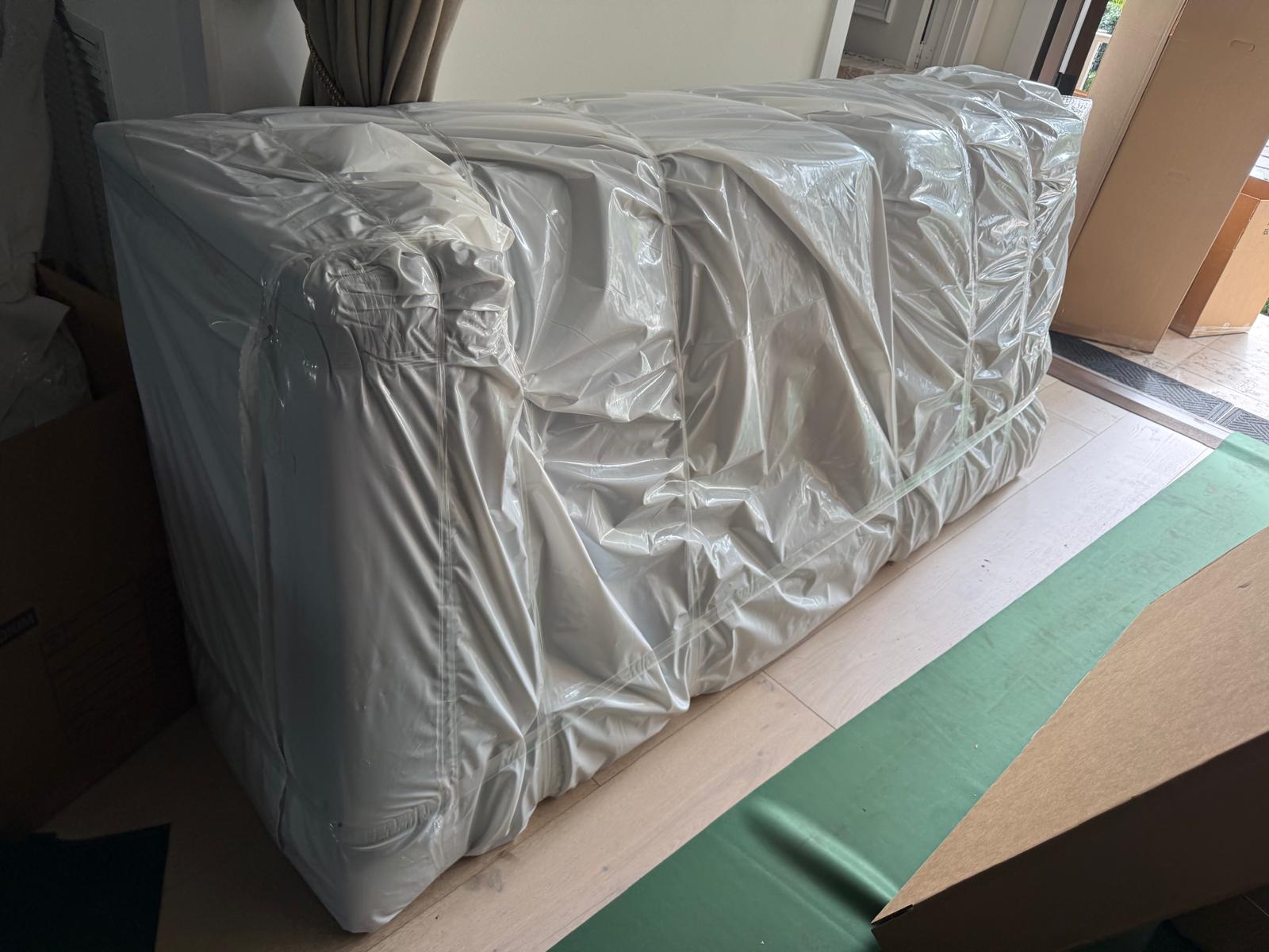 Sofa emballé de pellicule posé sur une protection de plancher