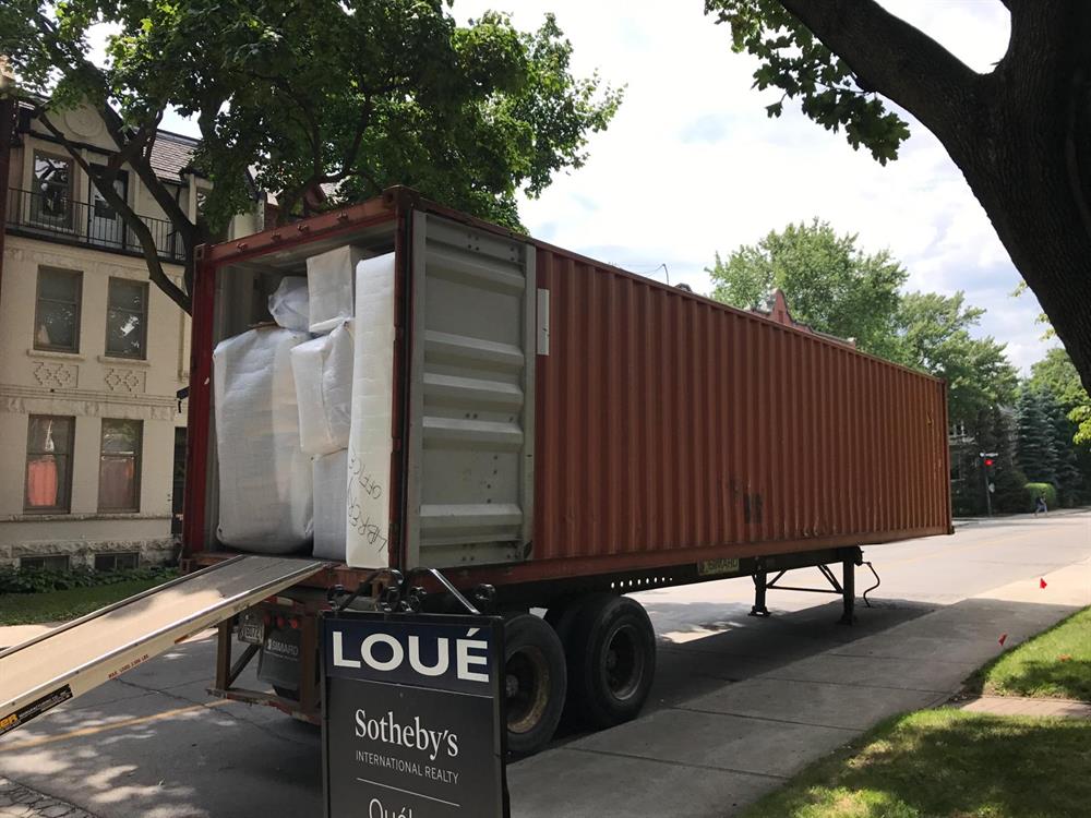 Conteneur d'entreposage livré sur camion devant une résidence