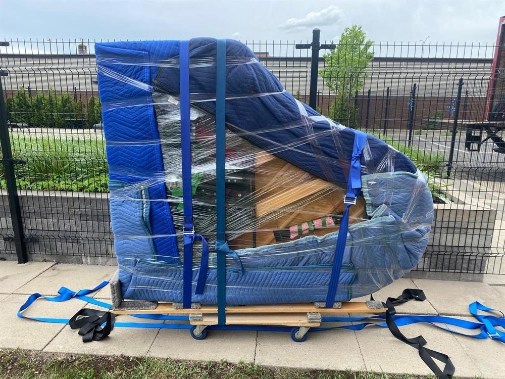 Piano à queue emballé et sécurisé avec l'équipement, sur un chariot