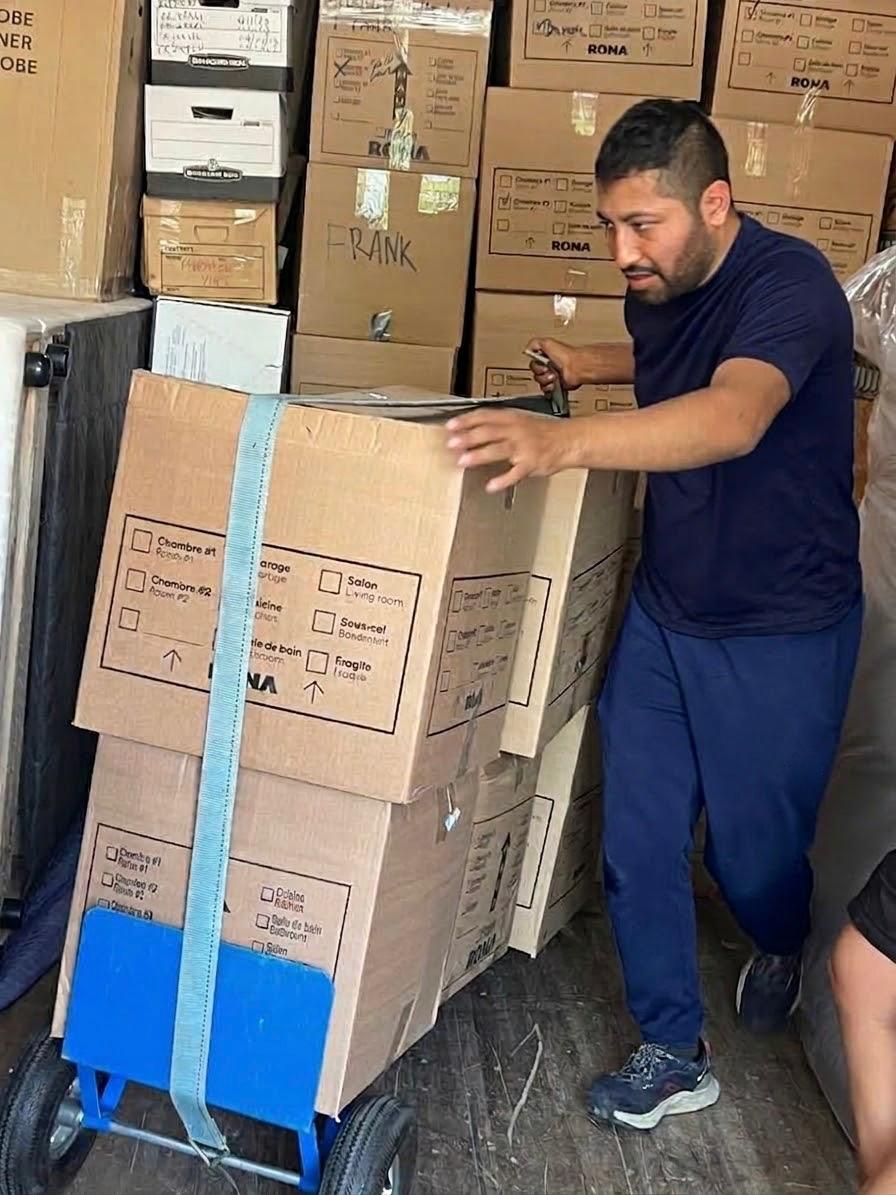 Déménageur transportant une pile de boîtes sanglées
