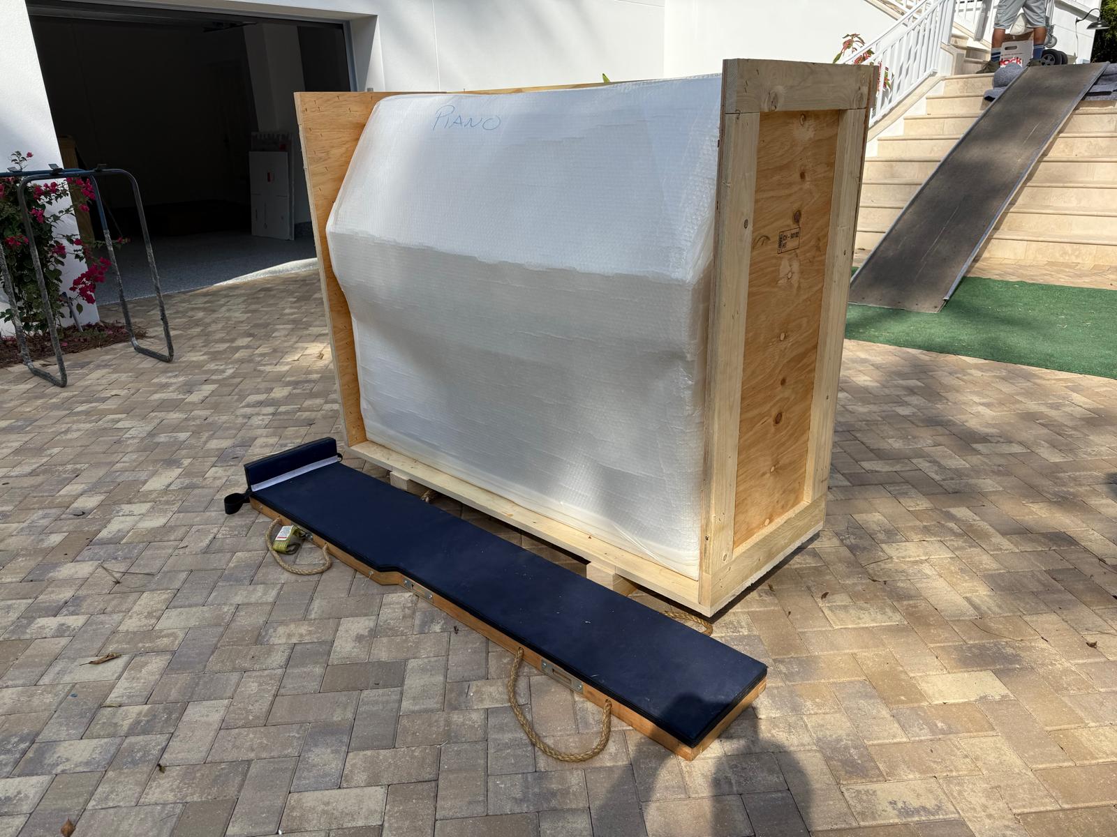 Piano emballé dans une caisse de bois construite sur mesure, avec rampe d'accès