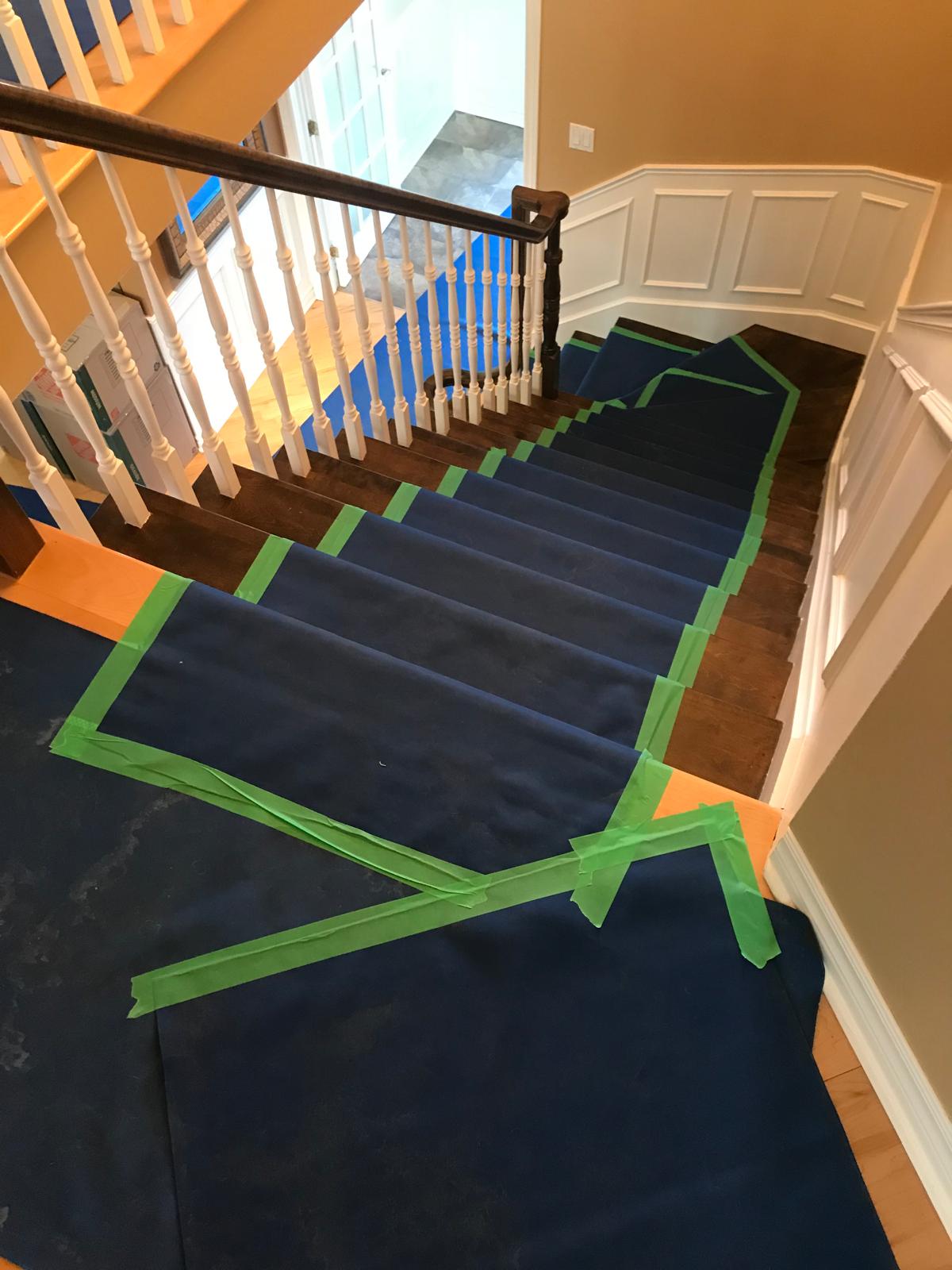 Escalier intérieur entièrement recouvert d'une protection noire fixée au ruban